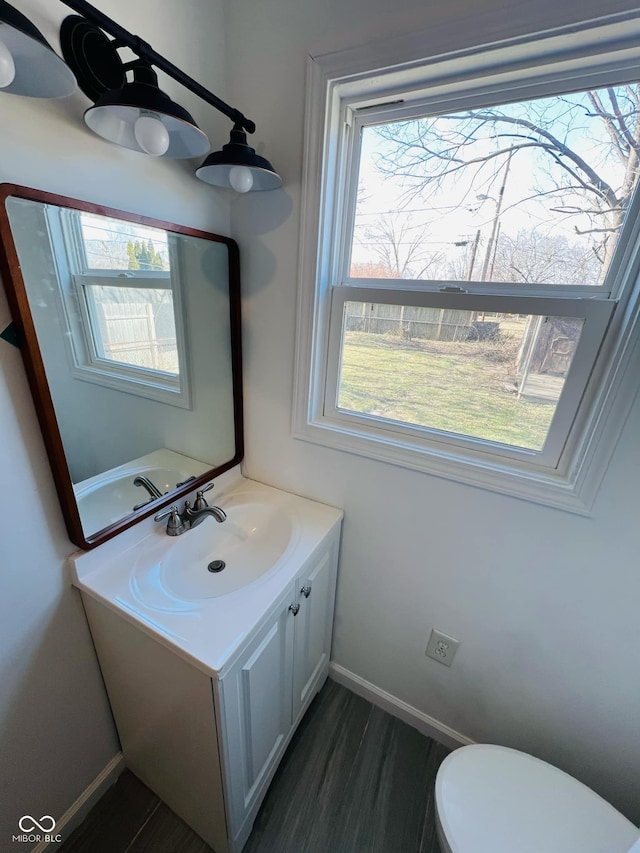 bathroom with hardwood / wood-style flooring, vanity, toilet, and a wealth of natural light