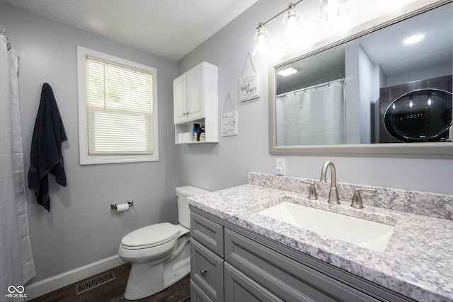 bathroom with vanity, toilet, hardwood / wood-style floors, and a textured ceiling