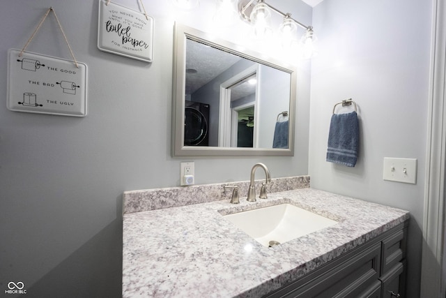 bathroom with vanity and washer / clothes dryer