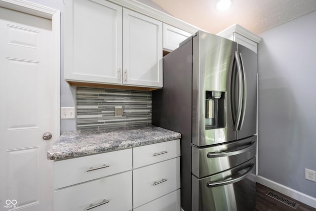 kitchen featuring tasteful backsplash, stainless steel refrigerator with ice dispenser, white cabinets, and dark hardwood / wood-style flooring