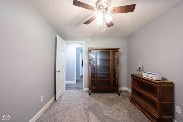 unfurnished bedroom featuring ceiling fan, carpet floors, and a textured ceiling