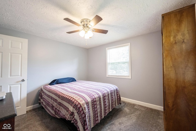 bedroom featuring ceiling fan, dark carpet, and a textured ceiling