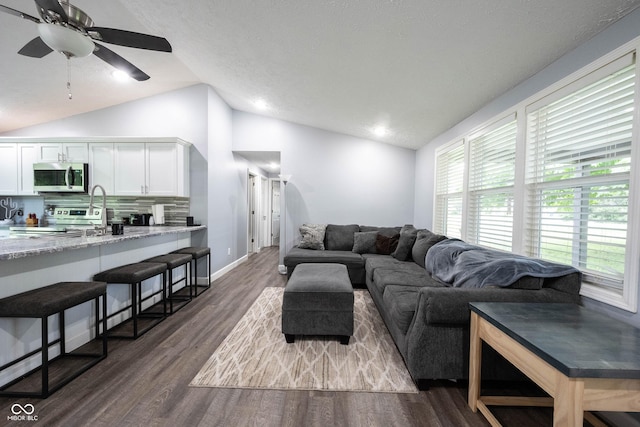 living room with vaulted ceiling, dark wood-type flooring, and ceiling fan