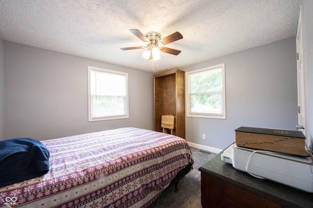 carpeted bedroom with multiple windows, a textured ceiling, and ceiling fan