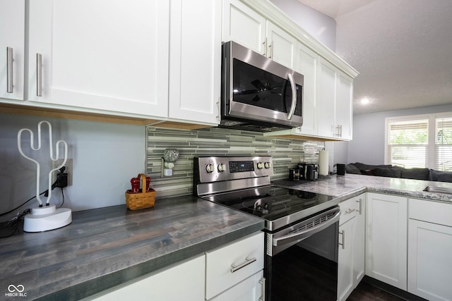 kitchen with stainless steel appliances, white cabinetry, sink, and decorative backsplash