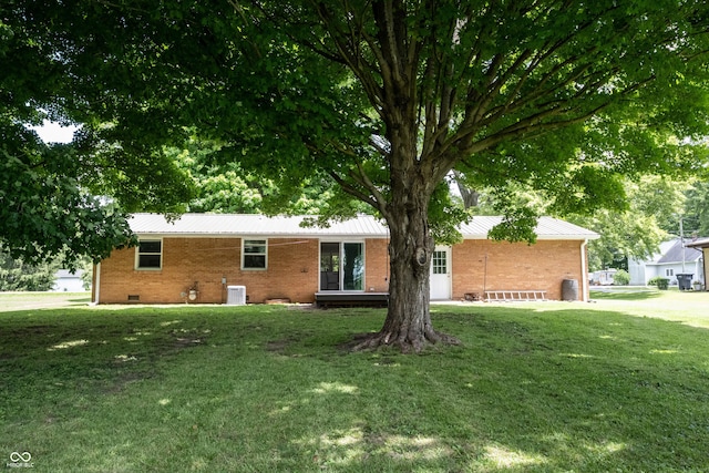 ranch-style home featuring a front lawn and central air condition unit