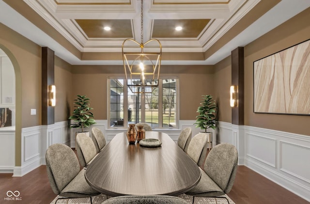 dining room with arched walkways, coffered ceiling, wood finished floors, an inviting chandelier, and crown molding