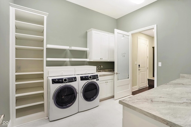 laundry room with a sink, cabinet space, and washer and dryer