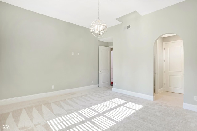 unfurnished room featuring arched walkways, a notable chandelier, light carpet, visible vents, and baseboards