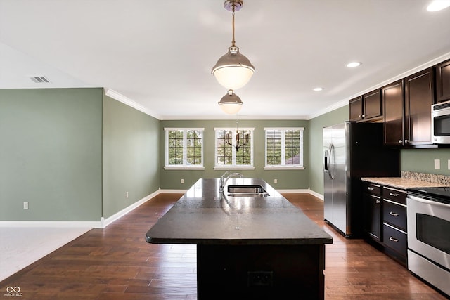 kitchen with appliances with stainless steel finishes, dark countertops, dark wood-style flooring, and a sink