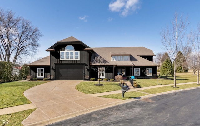 view of front of property featuring a garage, driveway, board and batten siding, and a front yard