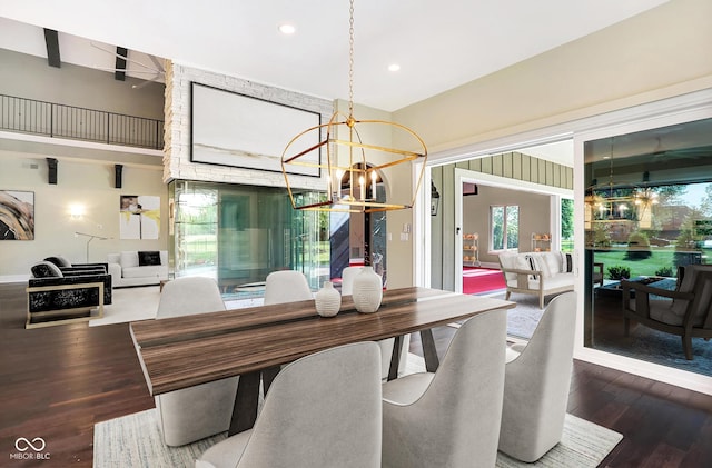 dining space with a chandelier, recessed lighting, a high ceiling, and wood finished floors