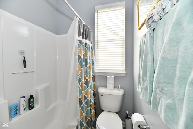 bathroom featuring a shower with curtain and toilet