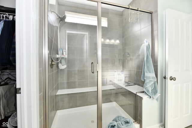 bathroom featuring a shower with door