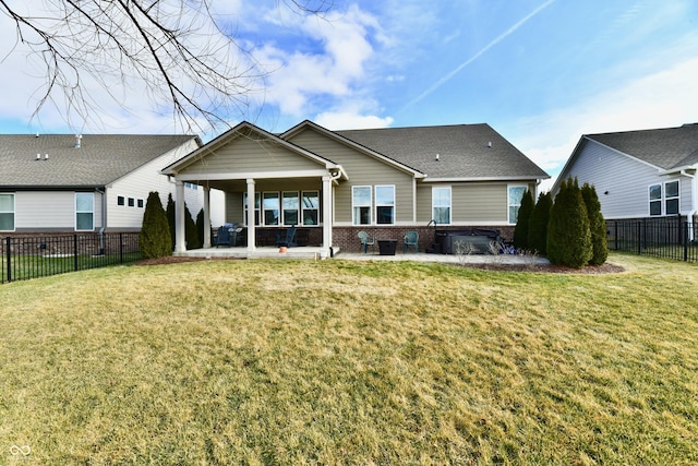 back of property featuring a lawn, a hot tub, and a patio