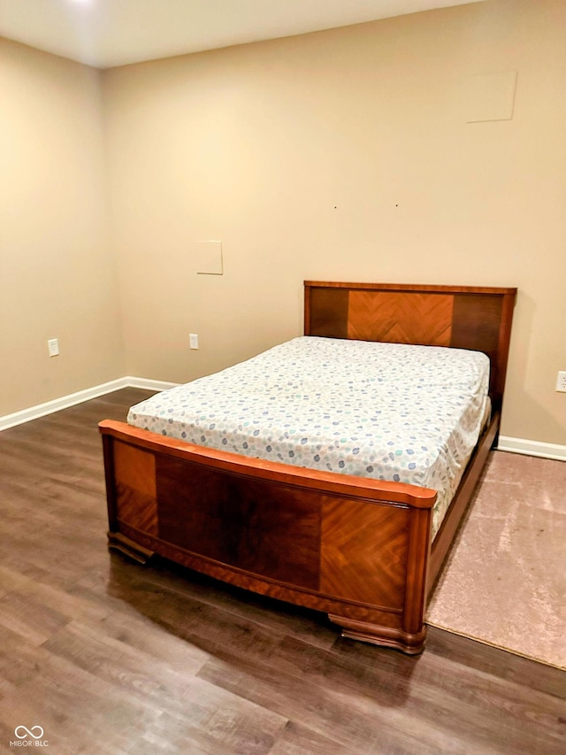 bedroom featuring baseboards and wood finished floors