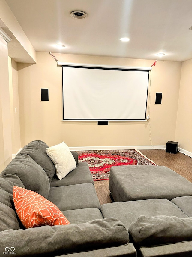 cinema room featuring baseboards, wood finished floors, and recessed lighting