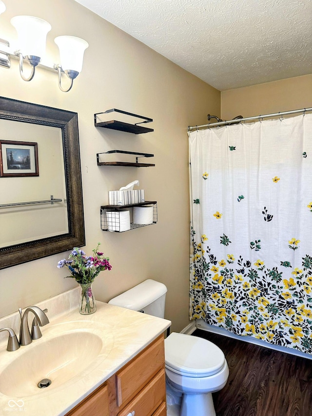 full bath with curtained shower, toilet, a textured ceiling, vanity, and wood finished floors