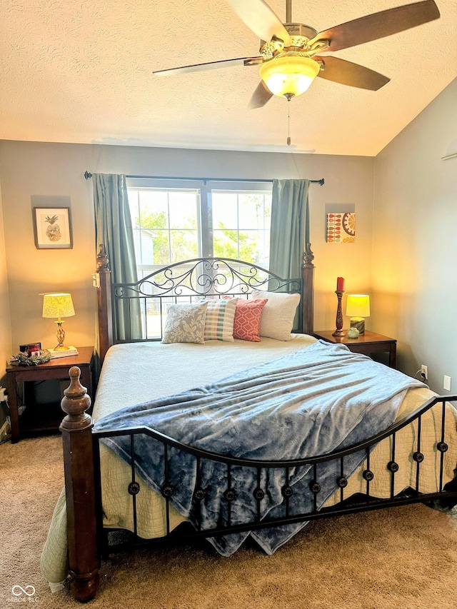 bedroom with a textured ceiling, carpet floors, and a ceiling fan