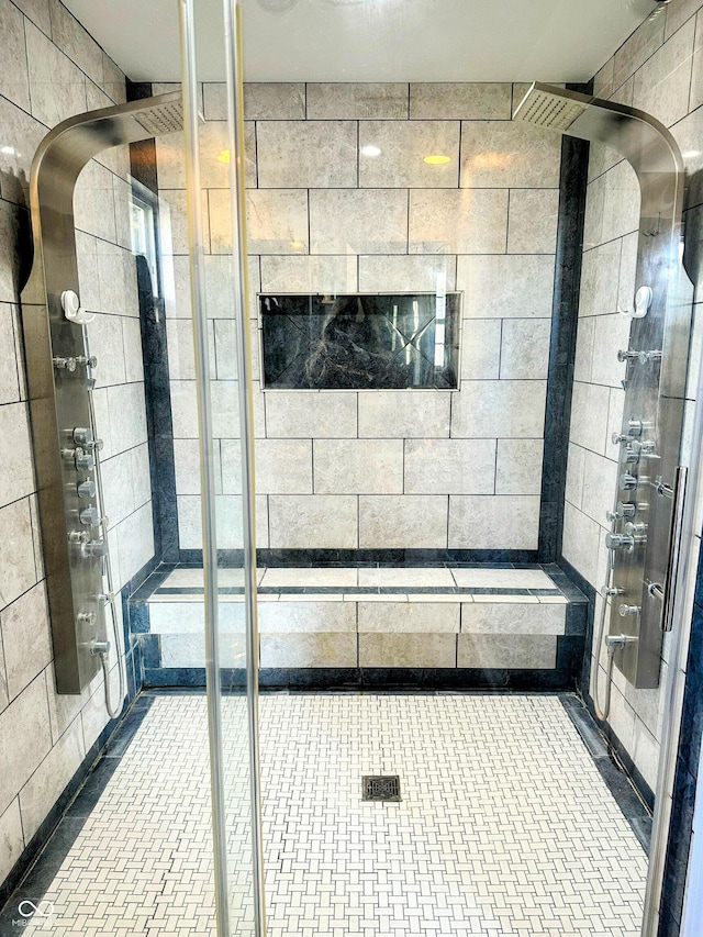 full bath featuring a shower stall and tile walls