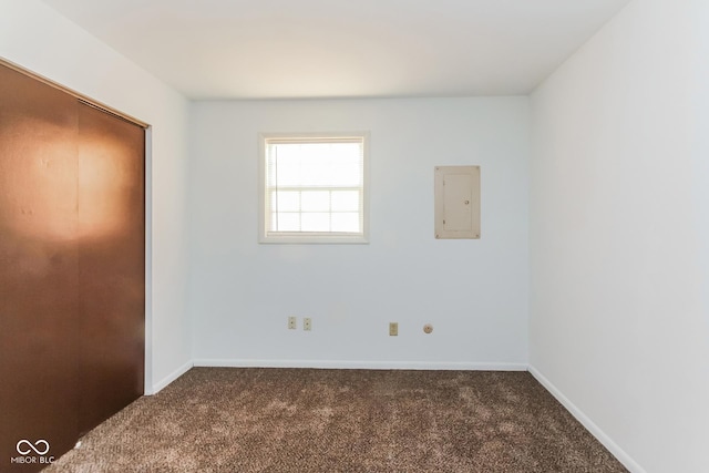 unfurnished bedroom with dark carpet and electric panel