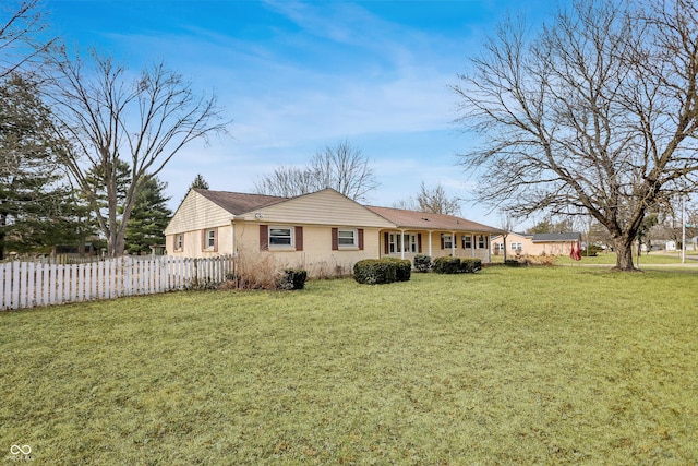 view of front facade featuring a front yard and fence