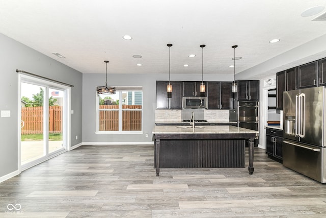 1324 Trailside Dr, Greenwood, IN 46143 - kitchen featuring stainless steel appliances, light wood-type flooring, recessed lighting, light stone countertops, and baseboards