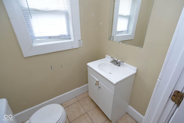 bathroom featuring vanity, plenty of natural light, tile patterned floors, and toilet