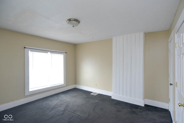 empty room featuring dark carpet