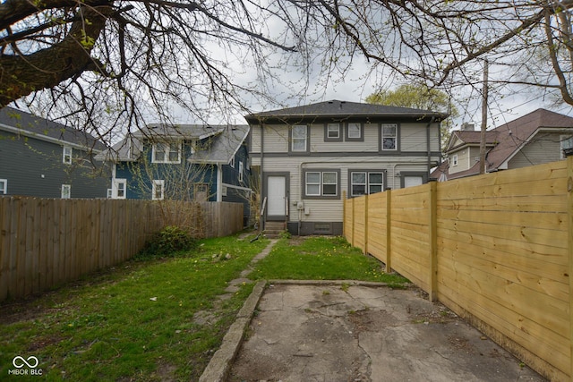 back of property with a patio area and a lawn