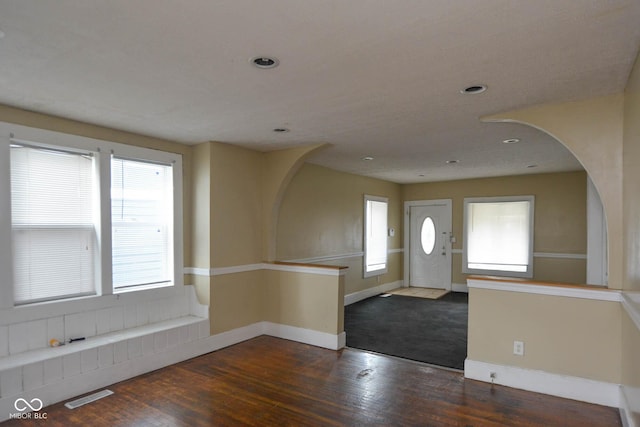 entryway with a wealth of natural light and dark hardwood / wood-style floors