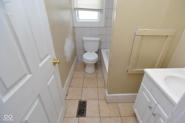 bathroom featuring tile patterned flooring, vanity, a tub, and toilet