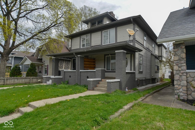 view of front of property with covered porch and a front lawn