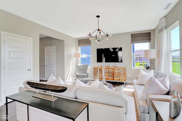 living room featuring hardwood / wood-style flooring and an inviting chandelier