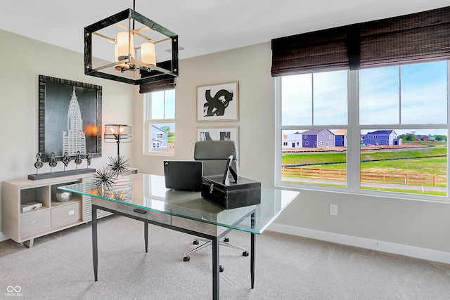 carpeted office with an inviting chandelier