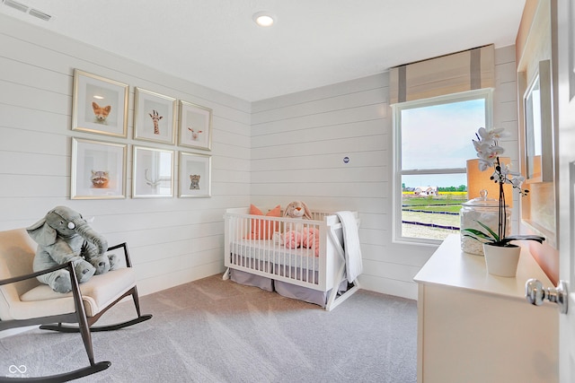 bedroom with light carpet and a crib