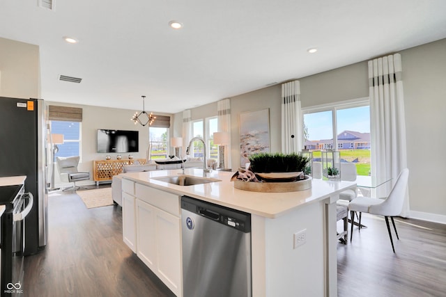 kitchen featuring dark hardwood / wood-style floors, sink, white cabinets, a kitchen island with sink, and stainless steel appliances