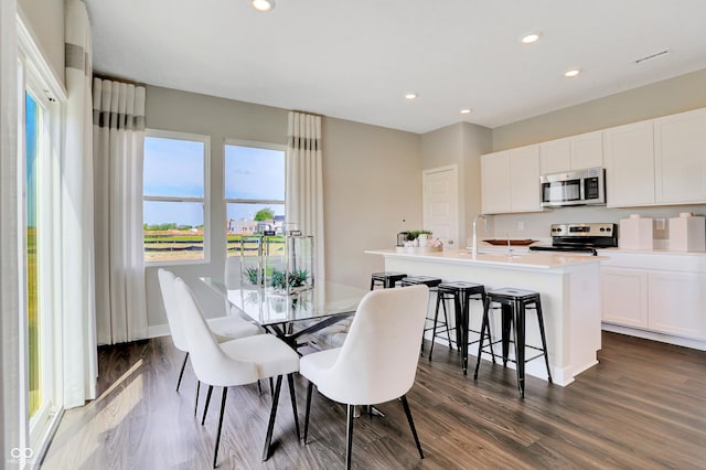 dining space with dark hardwood / wood-style floors and sink