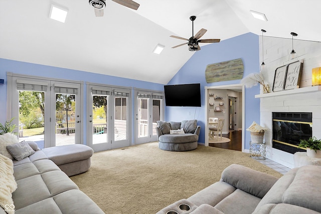 living room featuring ceiling fan, high vaulted ceiling, carpet floors, and a fireplace