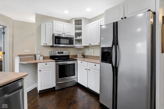 kitchen with stainless steel appliances, white cabinetry, and dark wood-type flooring