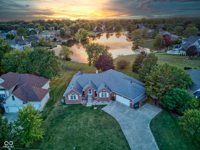 aerial view at dusk featuring a water view