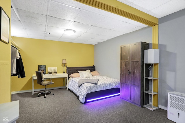 bedroom with carpet flooring and a drop ceiling