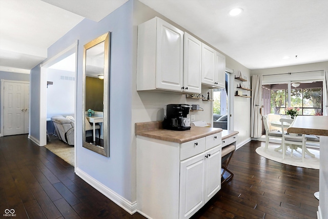 kitchen with dark hardwood / wood-style floors and white cabinets