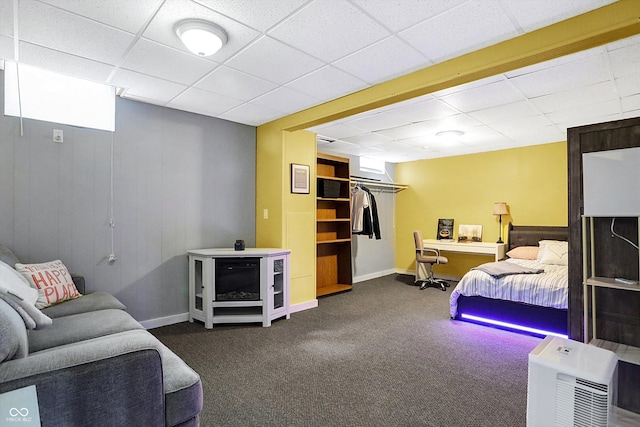 carpeted bedroom featuring a drop ceiling