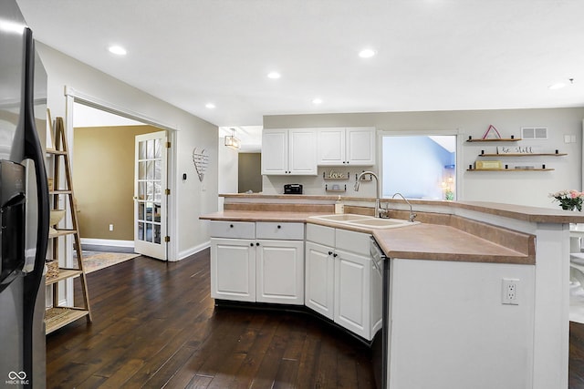 kitchen featuring an island with sink, appliances with stainless steel finishes, sink, and white cabinets