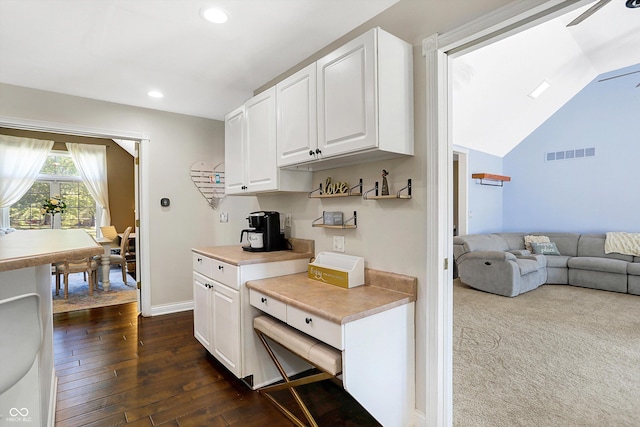 kitchen featuring white cabinetry, lofted ceiling, and dark hardwood / wood-style floors