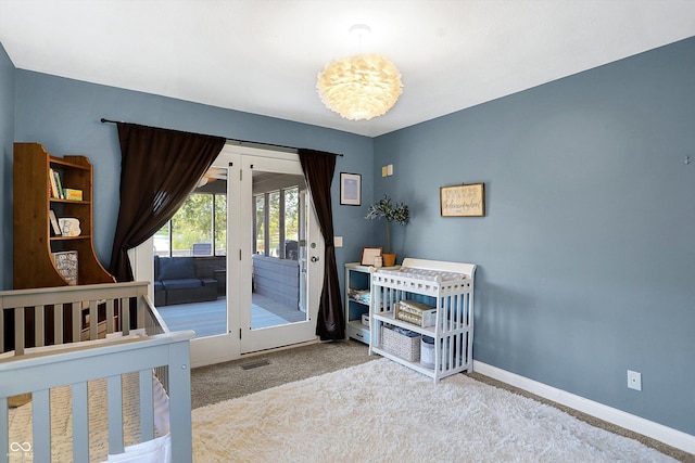 bedroom with access to outside and light colored carpet