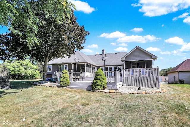 rear view of property with a wooden deck, a sunroom, and a yard