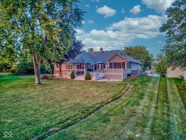 rear view of house with a yard, a patio area, and a sunroom