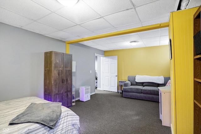 bedroom featuring dark carpet and a paneled ceiling